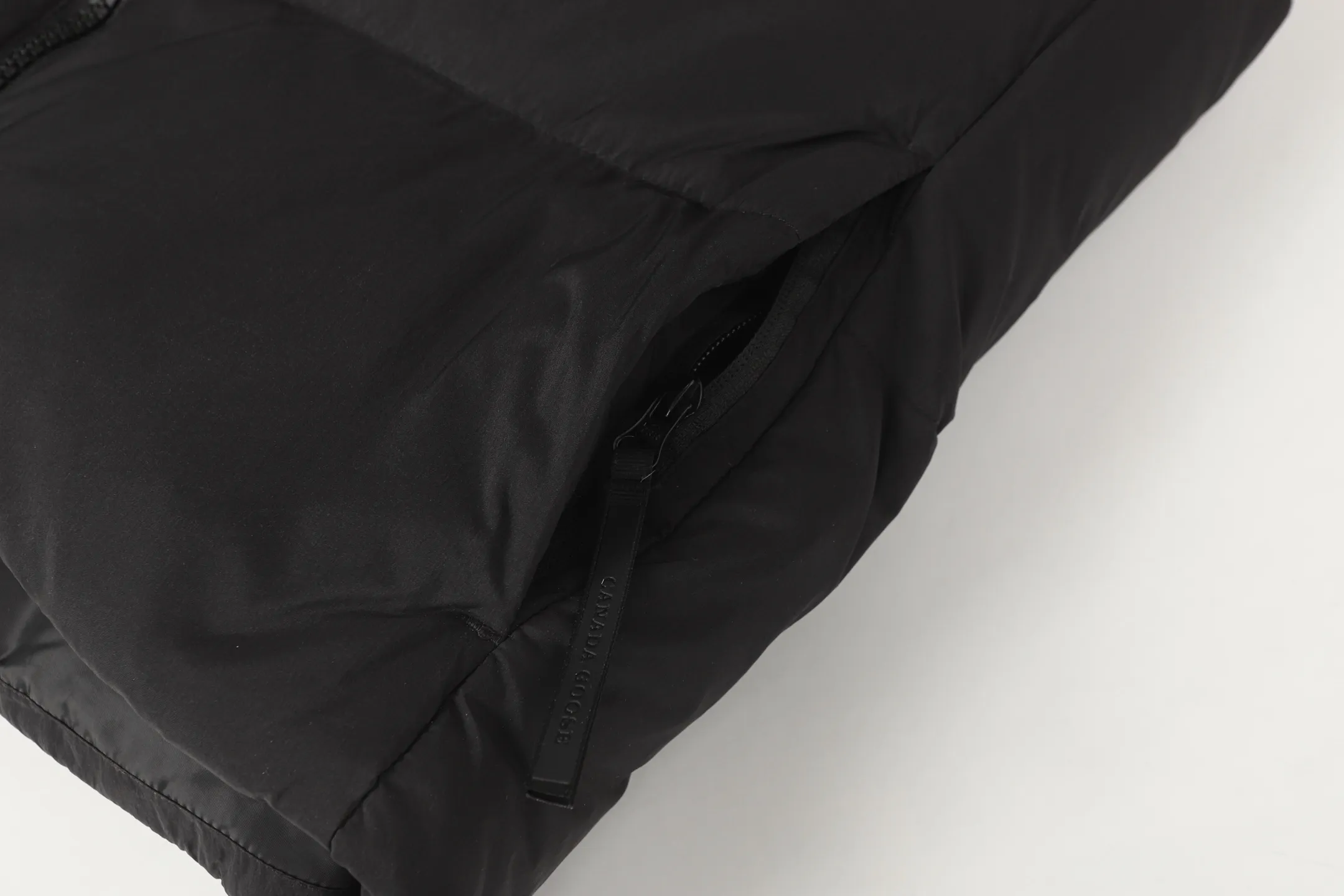 P560 Canada gooes Lawrence down vest (high version) The Lawrence down vest features a durable shell and quilted body, making it a must-have item for all seasons. The fabric has a durable soft touch. Longer hem at back for added protection. Reflective double-stripe grip tape at back. The Lawrence features an engineered down-filled collar to block strong winds, a two-way front zip and a longer rear hem.  Color: black with red label, black with black label, desert color, ocean blue Size: XS-2XL
